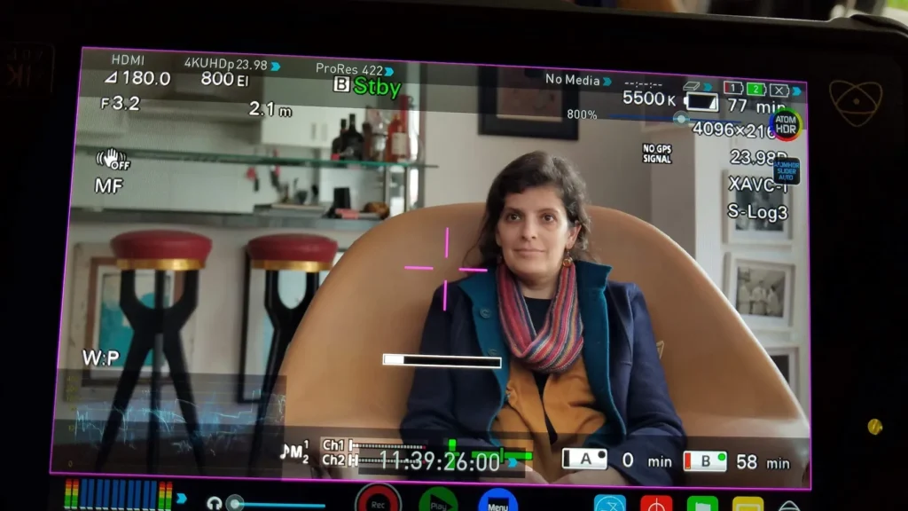 Camera monitor showing a woman mid-interview, lit with pro lighting and shot in cinematic S-Log.